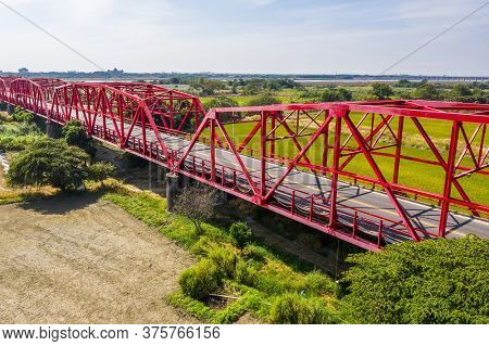 red famous Xilou Bridge over the river and farm in Yunlin county, Taiwan