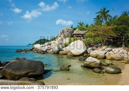 Tropical island paradise, Small bay among rocks with turquoise clear sea water, hurt behind big boulders. Romantic hidden vacation place. Koh Tao island popular destination travel holidays in Thailand