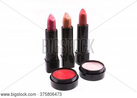 Three Red Lipsticks And Lip Gloss On White Background