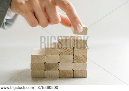 Women Hand Putting A Wooden Block On Top And Arranging Wooden Blocks Stacking, Business Concept For 