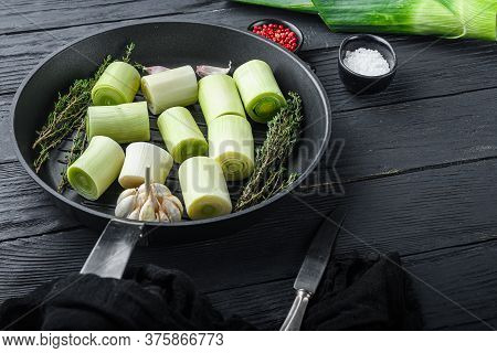 Raw Braised Leek Sultan On Grill Pan Uncooked With Herbs Ingredients  , On  Black Wooden Table Side