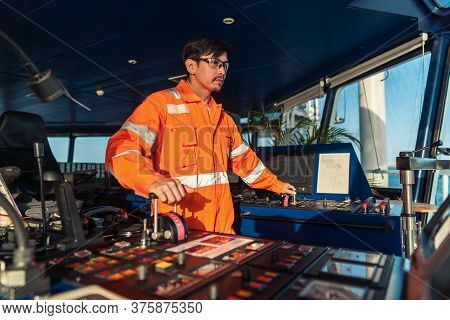 Filipino Deck Officer On Bridge Of Vessel Or Ship. He Is Speaking On Gmdss Vhf Radio