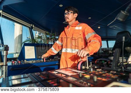 Filipino Deck Officer On Bridge Of Vessel Or Ship. He Is Speaking On Gmdss Vhf Radio