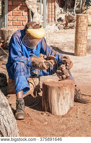 Omaruru, Namibia - May 31, 2011: A Worker Making A Wooden Sculpture At Tikoloshe Afrika Woodcarving 
