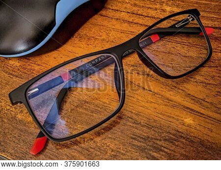 Fashionable Eye Glasses On The Yellow Wooden Table