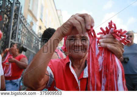 Salvador, Bahia / Brazil - Dec.4, 2019: Elderly Woman Holds Santa Barbara Ribbons During Celebration