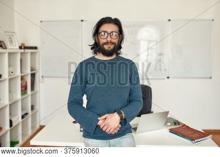 Giving Online Class. Portrait Of Young Happy Bearded Male Teacher Wearing Glasses Standing Against W