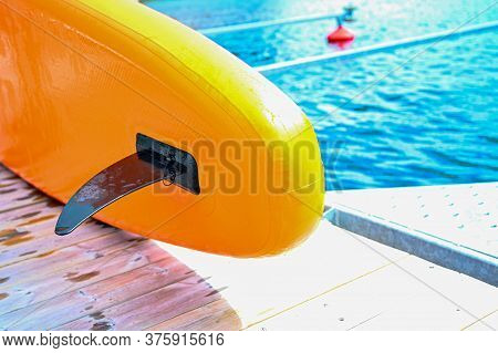 Black Fin On A Orange Sup Board