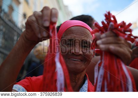 Salvador, Bahia / Brazil - Dec.4, 2019: Elderly Woman Holds Santa Barbara Ribbons During Celebration