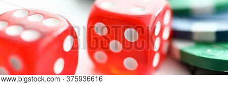 Close-up View Of Red Glass Dice Cubes On Playing Cards. Colourful Casino Chips On Table. Risk And Lu