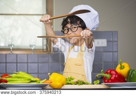 Asian Boy Son Cooking Salad Food Holdind Wooden Spoon With Vegetable Holding Tomatoes And Carrots, B