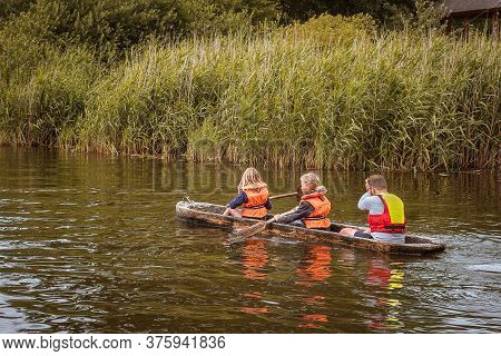 Father And Daughters In Life Jackets Paddeling In A Dugout Canoe, Lejre Denmark, July 9, 2020