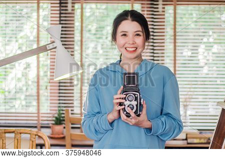 Stylish Vintage Smiling Female Photographer Holding Her Old Twin Lens Camera To Her Chest As She Com