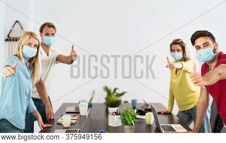 Young People Working In Co-working Creative Space Wearing Surgical Mask Protection For Preventing Co