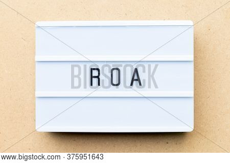 White Lightbox With Word Roa (abbbreviation Of Return On Assets) On Wood Background