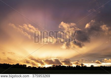 Beautiful Summer Sunset Sky With Colorful Vibrant Clouds And Sun Beams Across Whole Sky