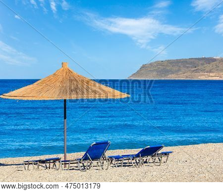 Summer Morning Pebbly Beach With Sunbeds And Strawy Sunshade (borsh, Albania).