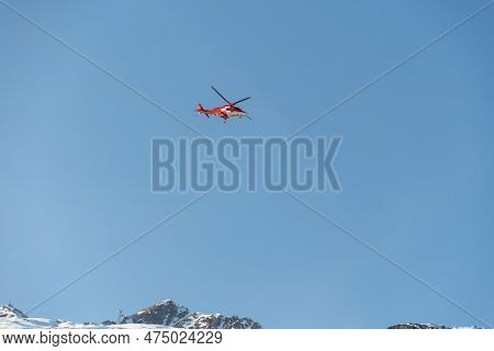 Saint Moritz, Switzerland, February 21, 2023 Rega Air Ambulance Helicopter In The Blue Sky