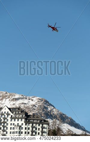 Saint Moritz, Switzerland, February 21, 2023 Rega Air Ambulance Helicopter In The Blue Sky