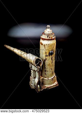 Old Manual Hydraulic Car Jack On A Black Background. Automotive Hydraulic Jack. Hand Tool. Tire Serv