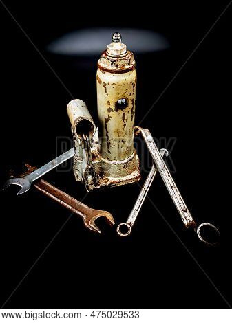 Hydraulic Car Jack And Wrenches On A Black Background. Automotive Hydraulic Jack. Hand Tool. Tire Se