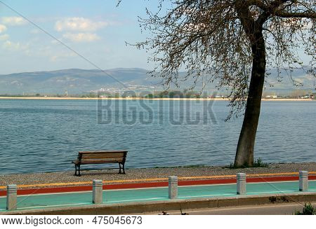 Landscape View Of Lake Iznik And Its Embankment With Bare Trees In The Foreground And A Blue Sky Wit