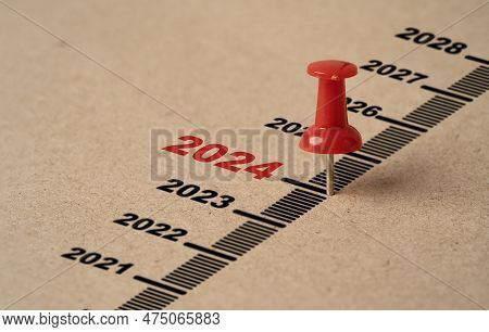Red Pin On Paper With 2024 Year For Preparation Merry Christmas And Happy New Year Concept.