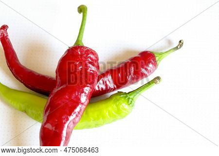 A Lot Of Hot Pepper On A White Background. A Few Chili Peppers On White. Pepper Is Red With Green Ta