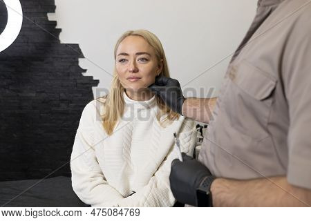 Doctor Pulls Female Facial Skin, Lifting Temple Area, Preparing To Face Reshape With Filler, Injecti