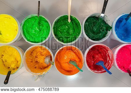 Top View, Colorful Fabric Printing Inks In White Buckets.\rstirring The Ink For Multicolored Tee Shi