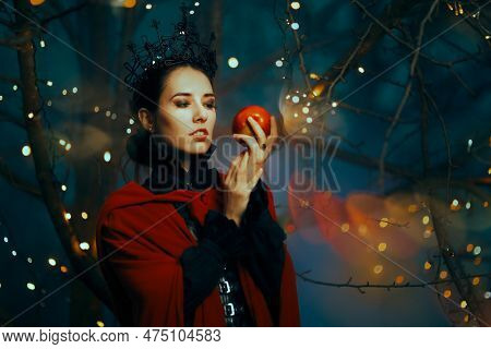 Evil Queen Holding A Red Poisonous Apple As Bait \nfantasy Fairy Tale Villain Planning A Witchcraft 