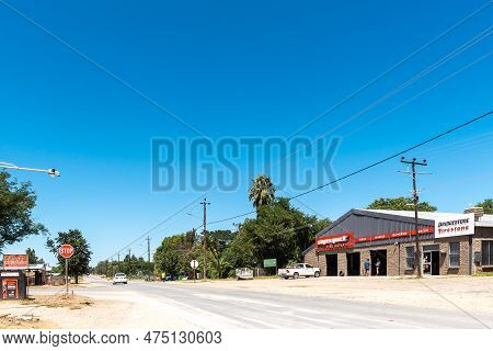 Douglas, South Africa - Mar 1, 2023: A Street Scene, With A Tyre Workshop, People And Vehicles, In D
