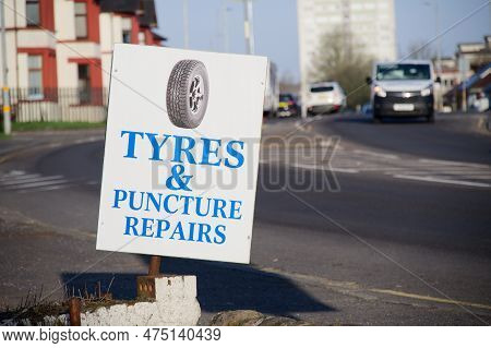 Tyre And Puncture Repairs Sign Outside A Garage