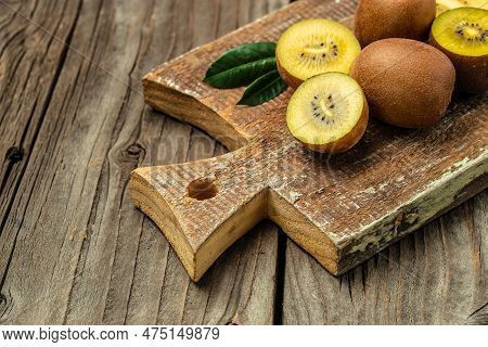 Closeup Ripe Golden Kiwi Fruit On Wooden Background. Healthy Fruits Concept. Place For Text, Top Vie