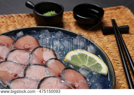 Raw Mackerel Slices, Ice Cubes, Lemon Served With Vasabi And Soy Sauce On Wicker Mat, Closeup. Fish 