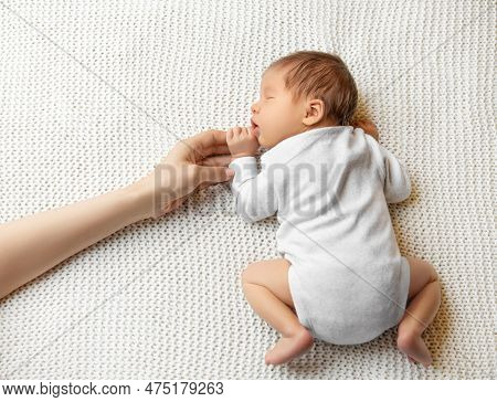 Baby Holding Mother Hand. Sleeping Newborn Lying Down On Stomach. Beautiful Infant In Onesie Sleep O