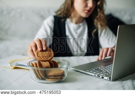 Unconscious Eating. Bad Habits. Selective Focus Of Hand Of Concentrated Female Working On Laptop At 