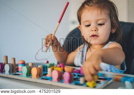 One Year Old Baby Girl Playing, Learning Numbers, Count With Help Of A Wooden Math Educational Toy. 