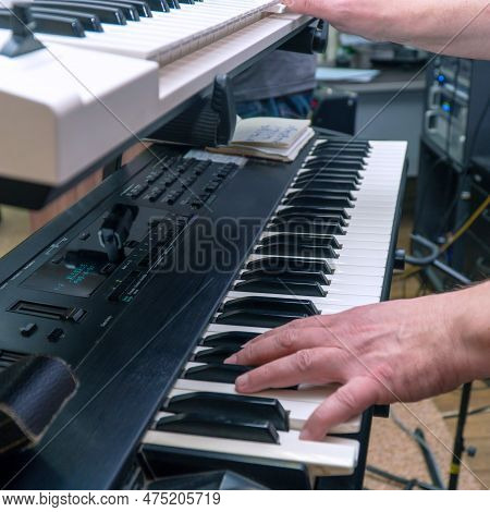 A Pianist Or Keyboardist Plays A Synthesizer