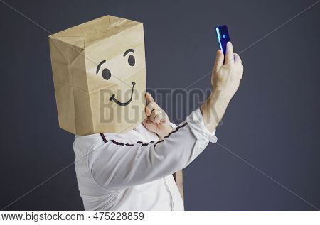 A Man In A White Shirt With A Paper Bag On His Head, With A Drawn Smiley Face, Is Talking On A Video