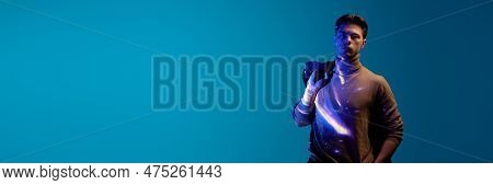 Handsome, Serious, Young Guy With Digital Kosmos Reflection On Clothes And Body Posing Against Blue 
