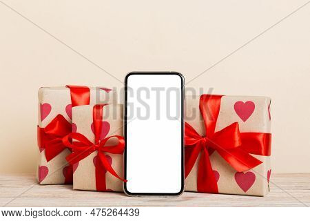 Mobile Phone With Blank Screen On Colored Background With Hearts, Calendar And Gift Box, Valentine D