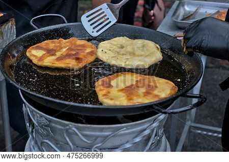 Romanian And Moldovan Pies Are Fried In A Large Frying Pan. Traditional Homemade Round Pies - Placin