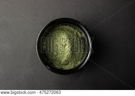 Green Powder In A Small Ceramic Bowl,  On A Black Background.  Super Food Or Marijuana Kief Concept