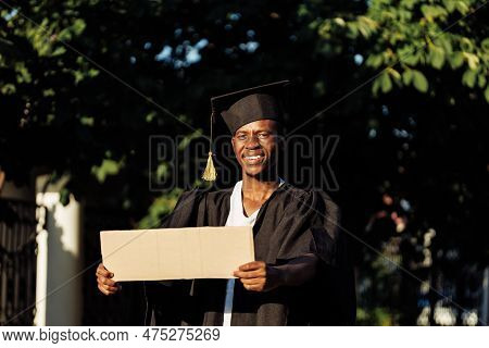 Portrait Of Happy Black Guy Standing With Empty Cardboard Poster On Street Looking For Job, Free Cop