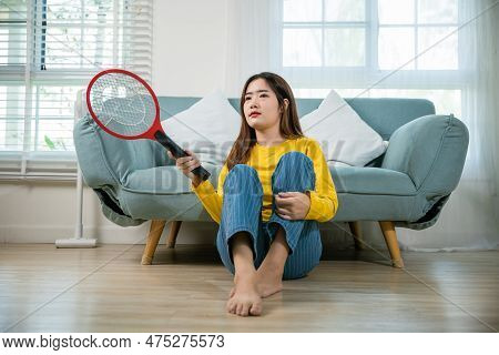 Asian Young Woman Sitting Floor Using Mosquito Swatter Or Electric Net Racket, Female Killing Mosqui