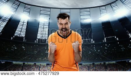 Growing Winning Spirit Before Game. Emotional Man, Professional Football Sportsman In Orange Uniform