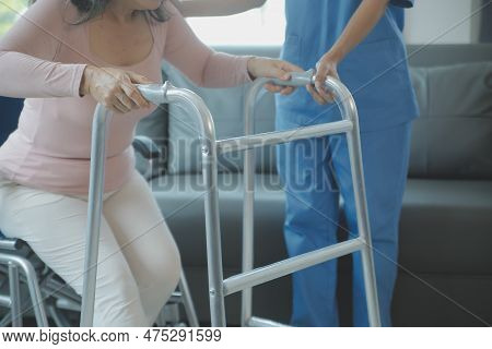 Asian Young Woman Nurse At Nursing Home Take Care Disabled Senior Man. Caregiver Doctor Serve Physic