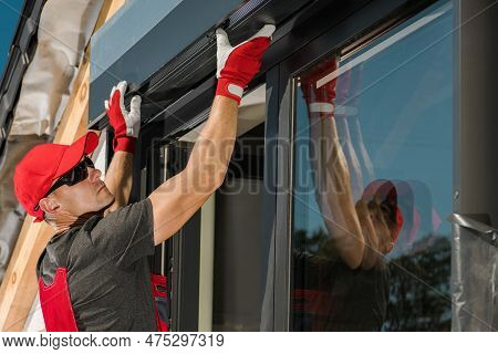 Caucasian Professional Worker Installing Outdoor Sun Shade Electric Roller Shutters
