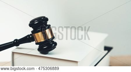 Closeup Wooden Gavel Hammer And Law Book In Empty Law Firm Or White Lawyer Office Background As Just